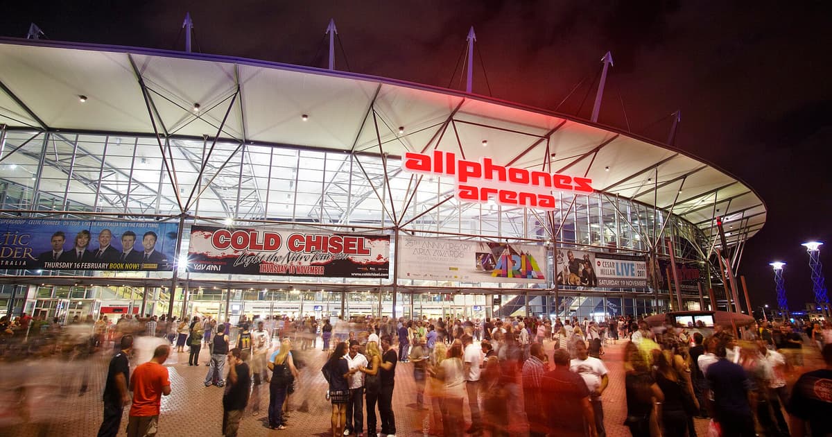 The Sydney Olympic Park arena hosting Spence vs Tszyu, lit up at night with crowds outside